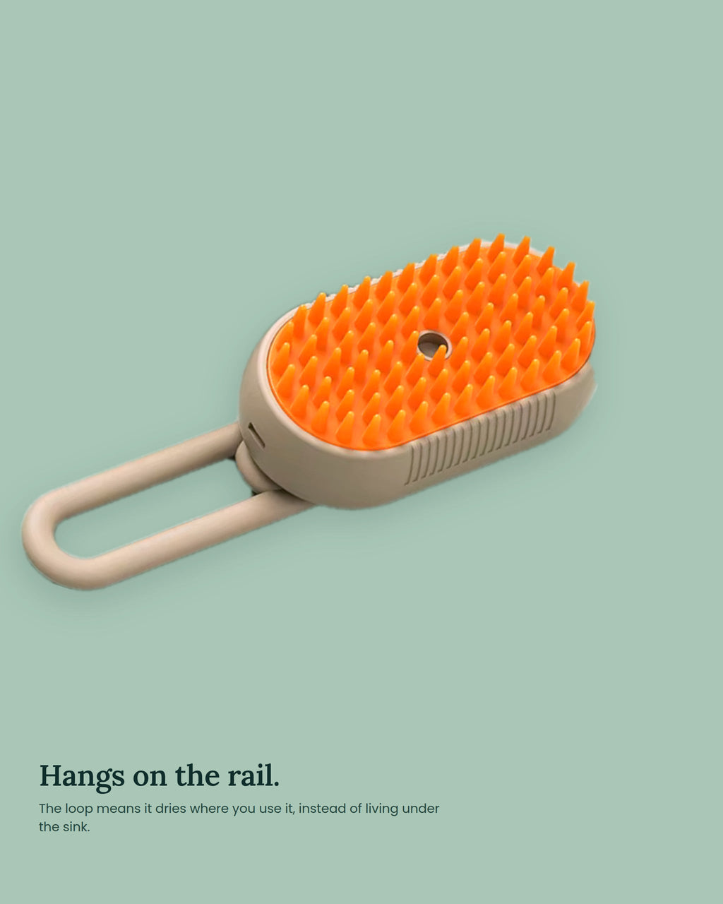 The brush hanging by its built-in loop from a shower rail to dry